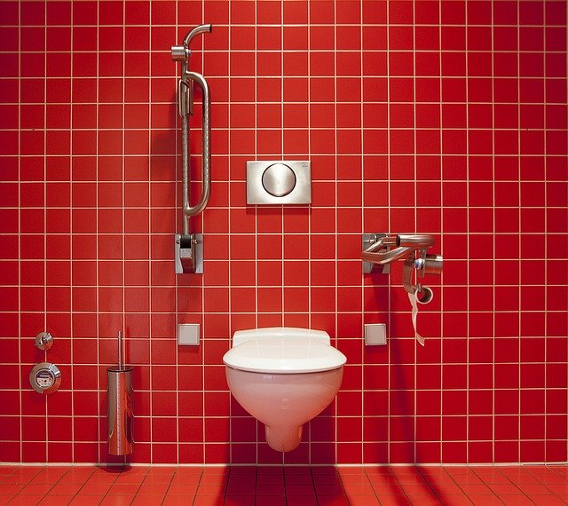 Toilette vor roter Fliesenwand