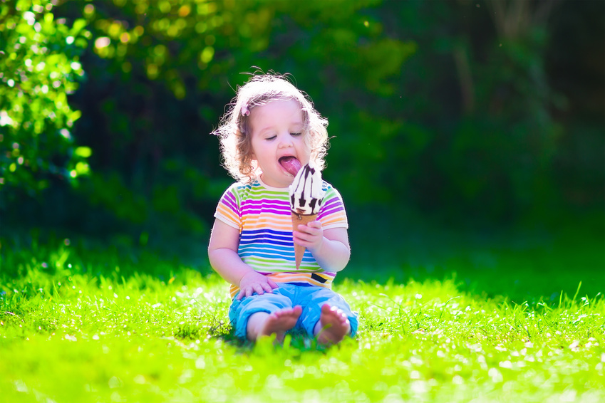 Ein kleines Mädchen isst ein Eis.