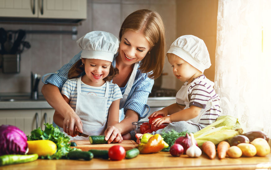 Eine Mutter kocht mit ihren kleinen Kindern.